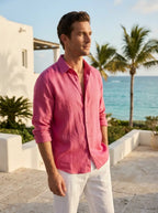 Male model wearing the raspberry linen shirt in a sunny resort setting
